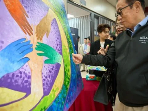 Giới mộ điệu hào hứng chấm và chạm vào tranh gây quỹ ủng hộ đồng bào miền Trung