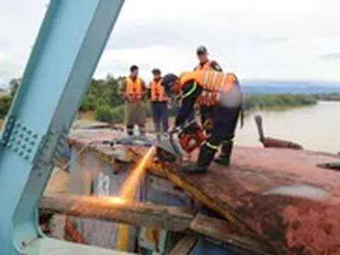 Cảnh sát và cả trăm người tham gia giải cứu cầu đường sắt bị sà lan mắc vào