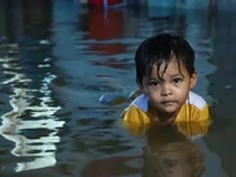 Người dân đắp ‘đê’ trước cửa nhà, trẻ em bơi giữa dòng triều cường đạt đỉnh tại TP.HCM